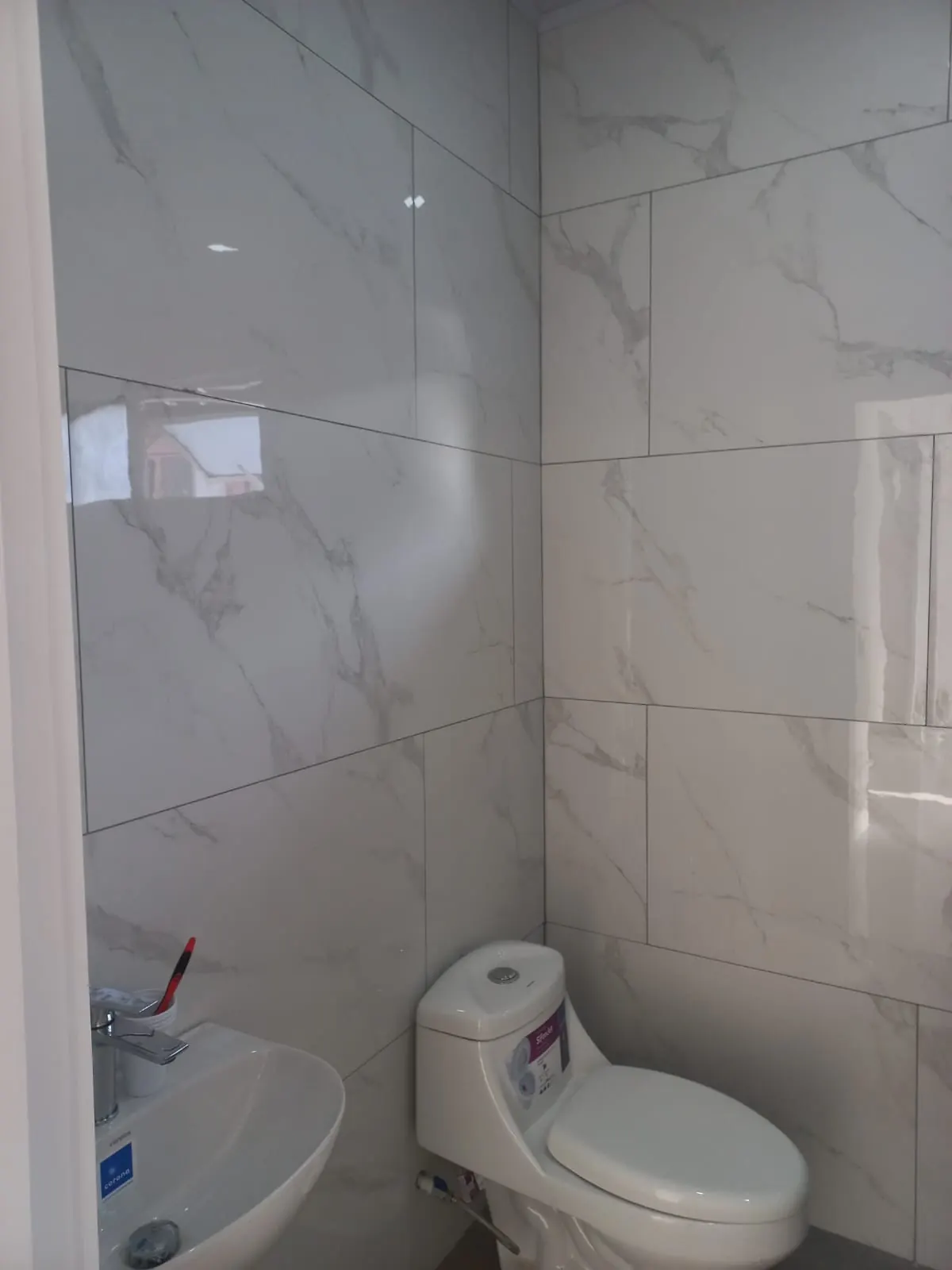 Baño con azulejo tipo marmol.