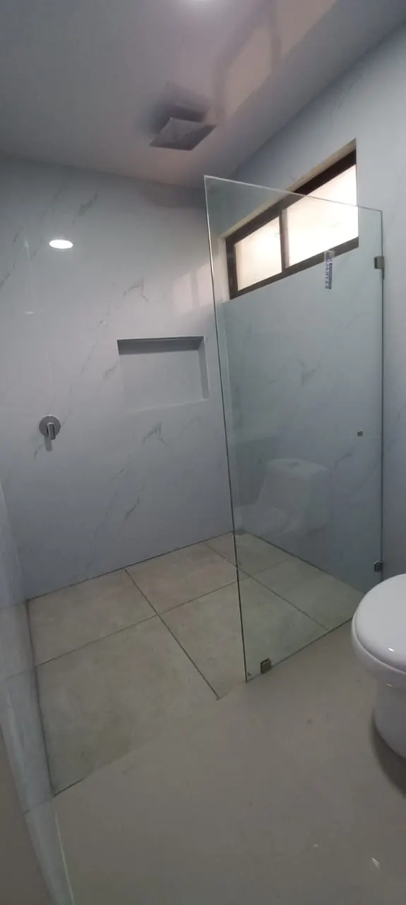 Ducha de vidrio y azulejos tipo marmol