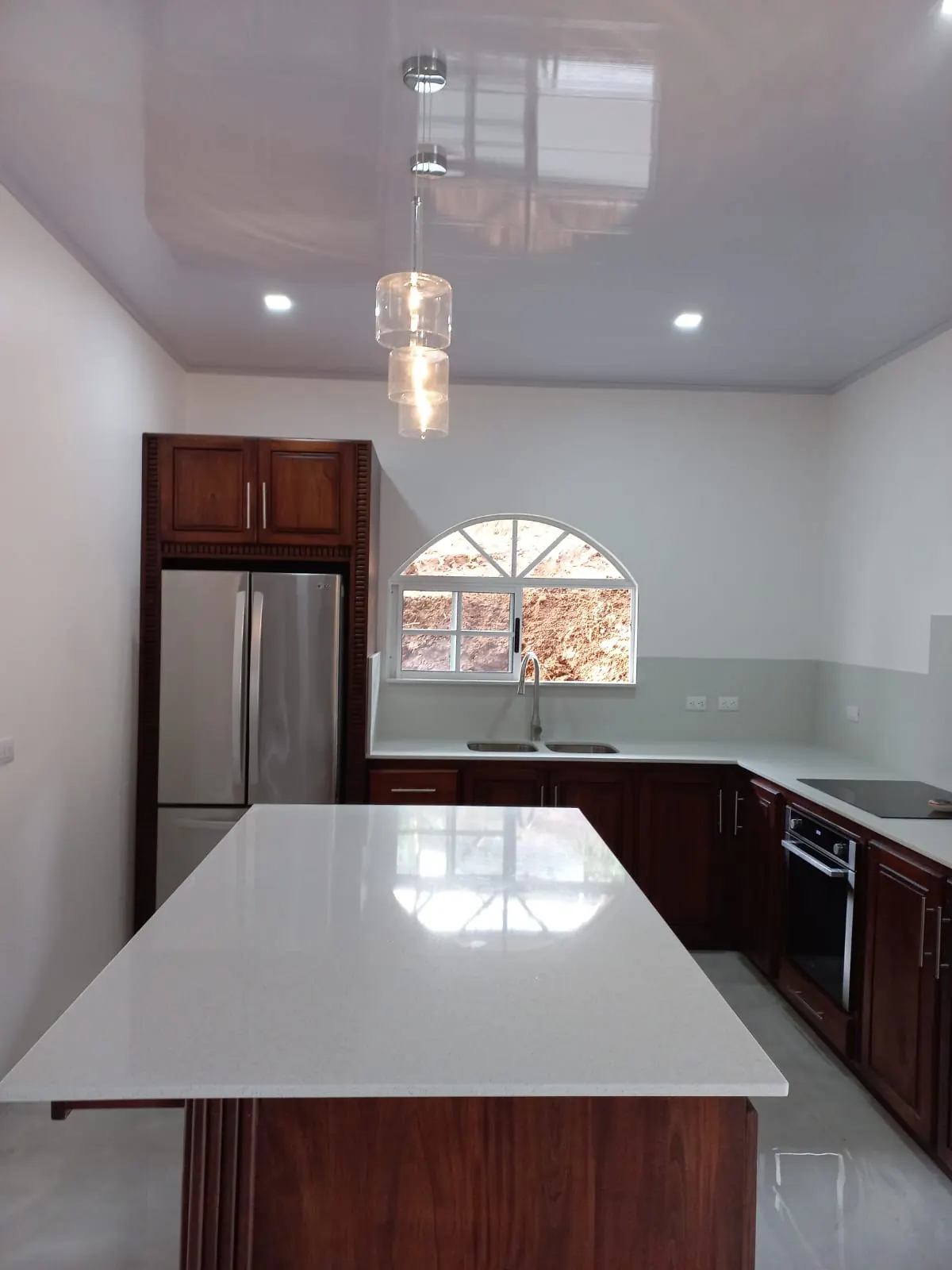 Cocina con isla y gabinetes de madera.