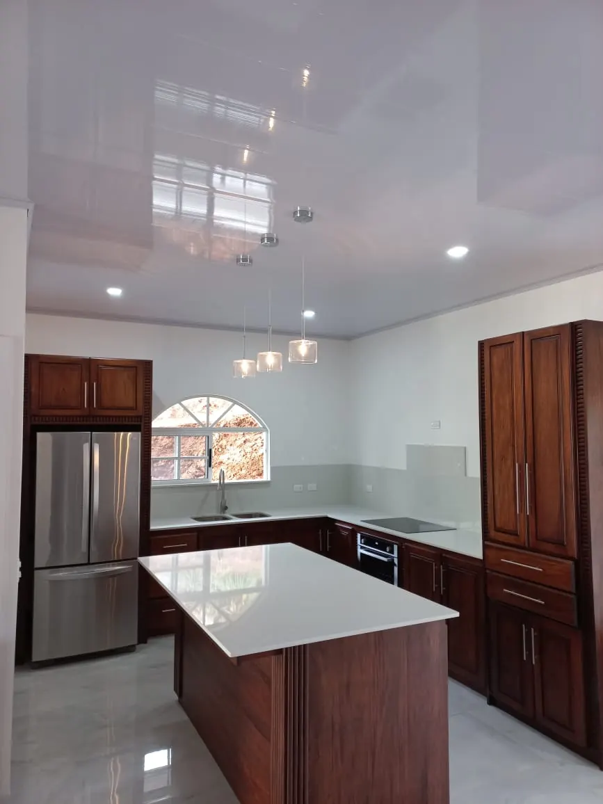 Cocina con isla y lamparas colgantes.