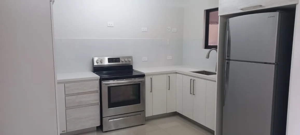 Cocina con gabinetes y electrodomesticos.