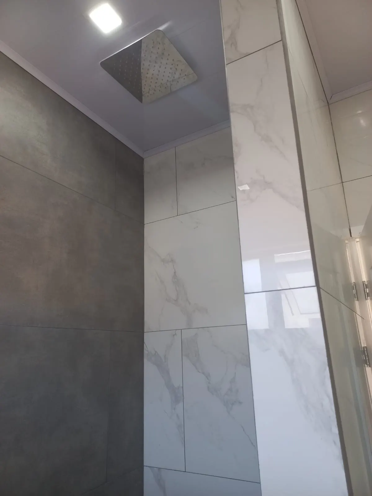 Ducha con azulejos tipo marmol.